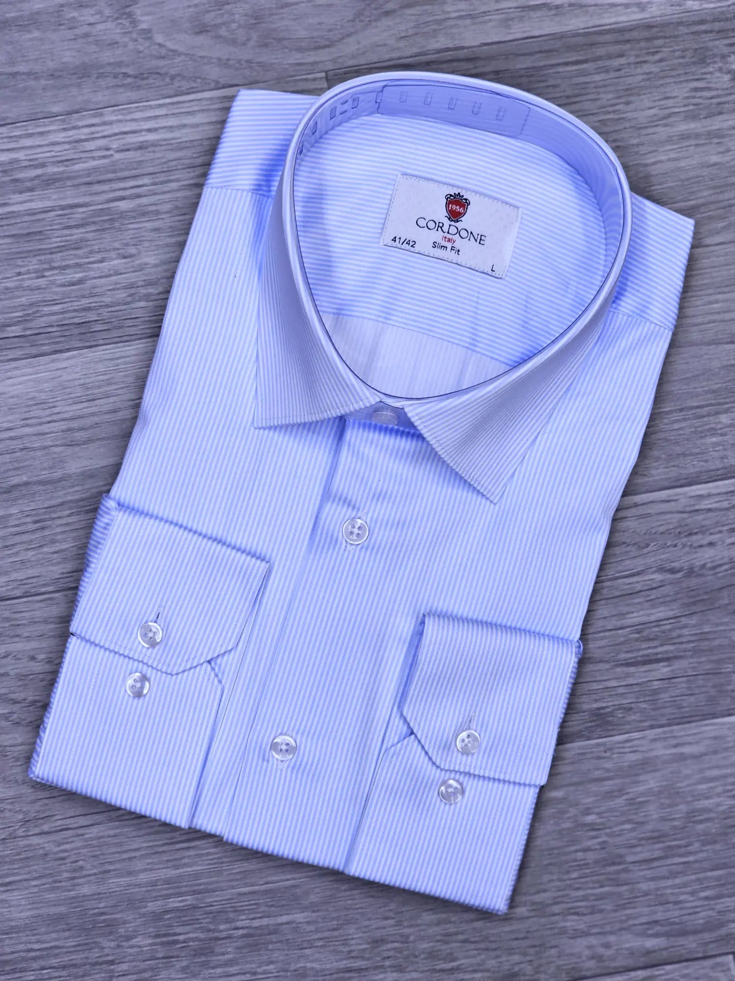 Blue checkered dress shirt with collar label on a wooden surface