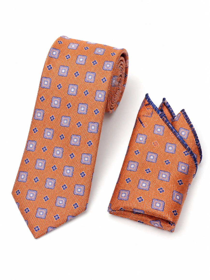 Infynite burnt orange and lavender geometric square floral medallion tie and pocket square set with fine linen-weave base and navy-bordered pocket square laid flat on white background