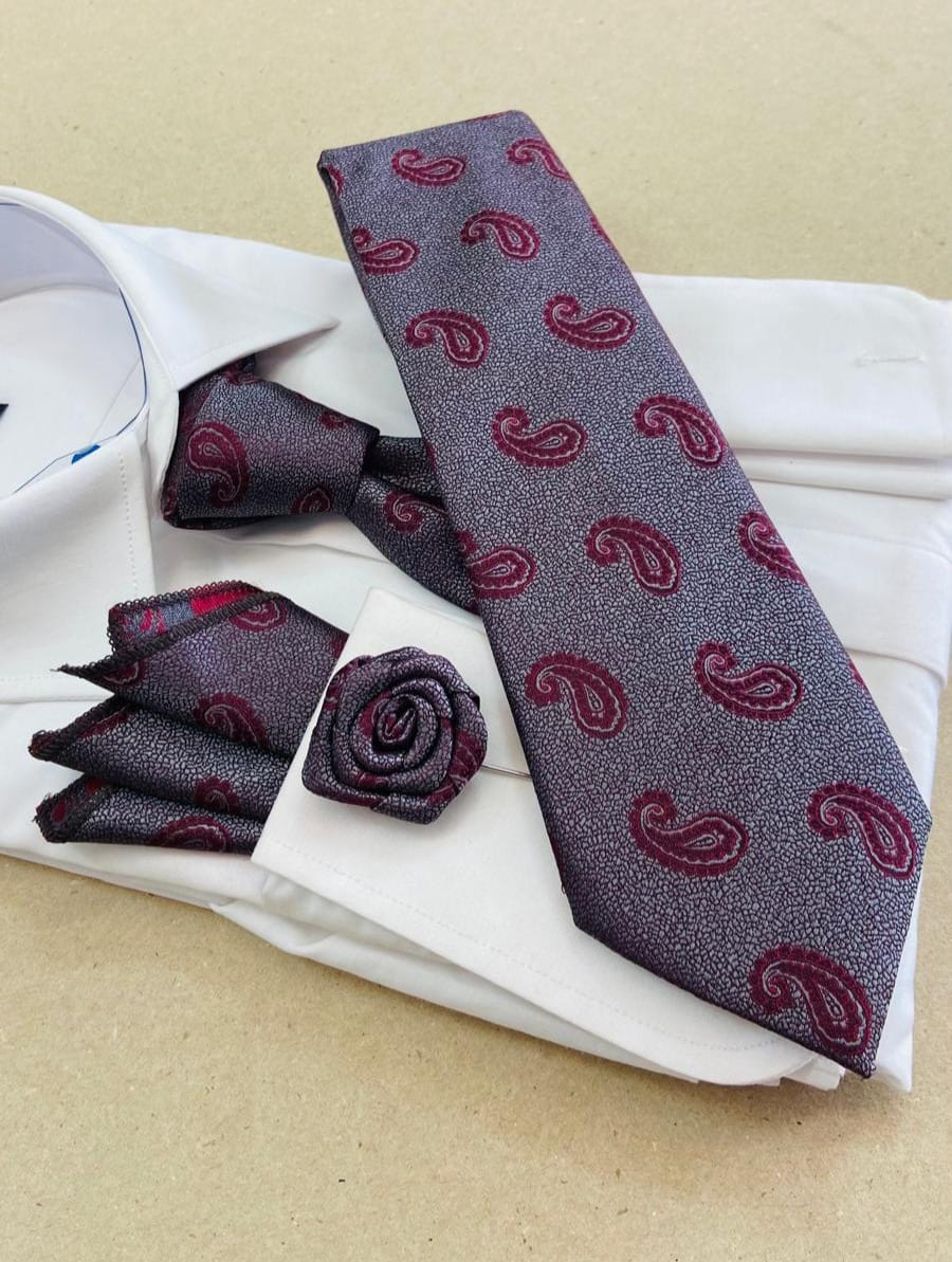 Gray tie with red paisley pattern, pocket square, and cufflinks on a white shirt.
