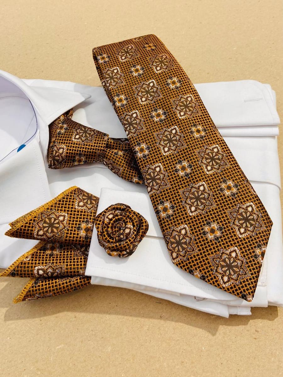 Brown patterned tie, bow tie, and pocket square set on a beige background