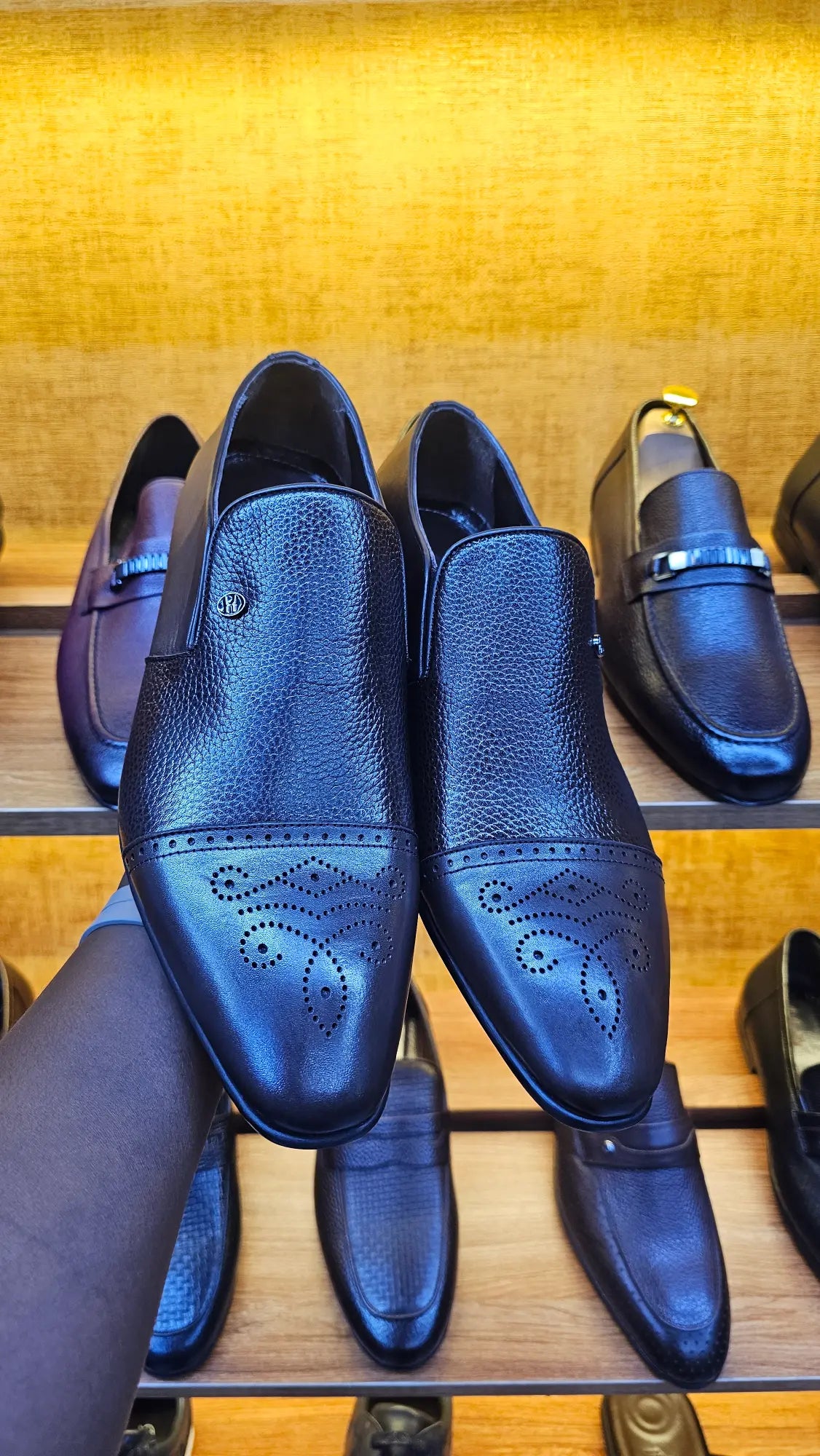 Pair of black leather shoes on a wooden surface