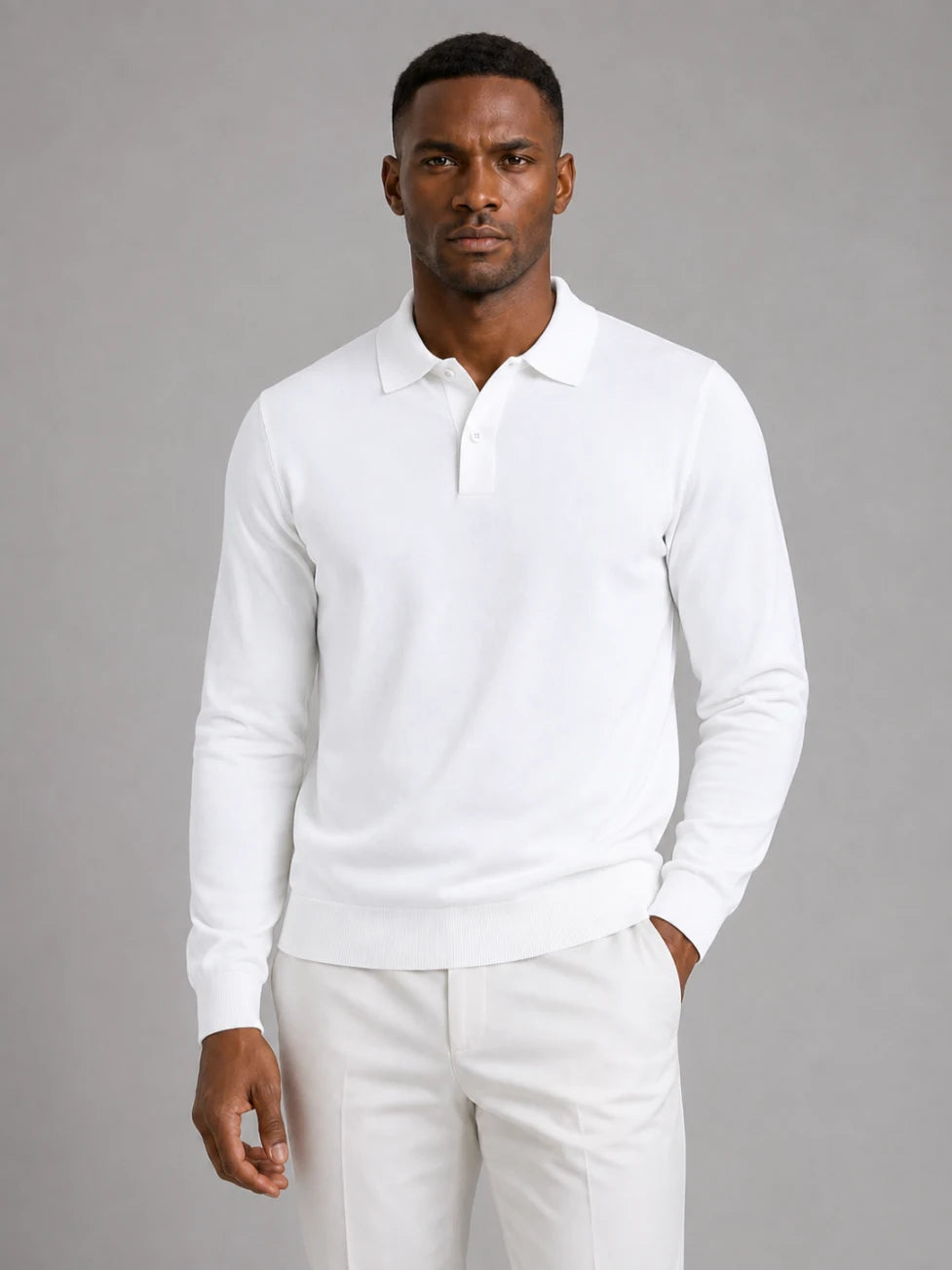 African man wearing an Infynite white long-sleeve knitted polo sweater with off-white trousers.