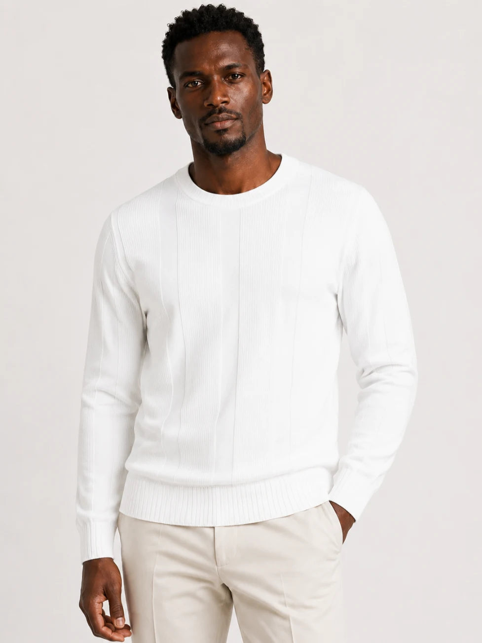 African man wearing an Infynite white crew-neck sweater with alternating ribbed and smooth vertical knit panels.