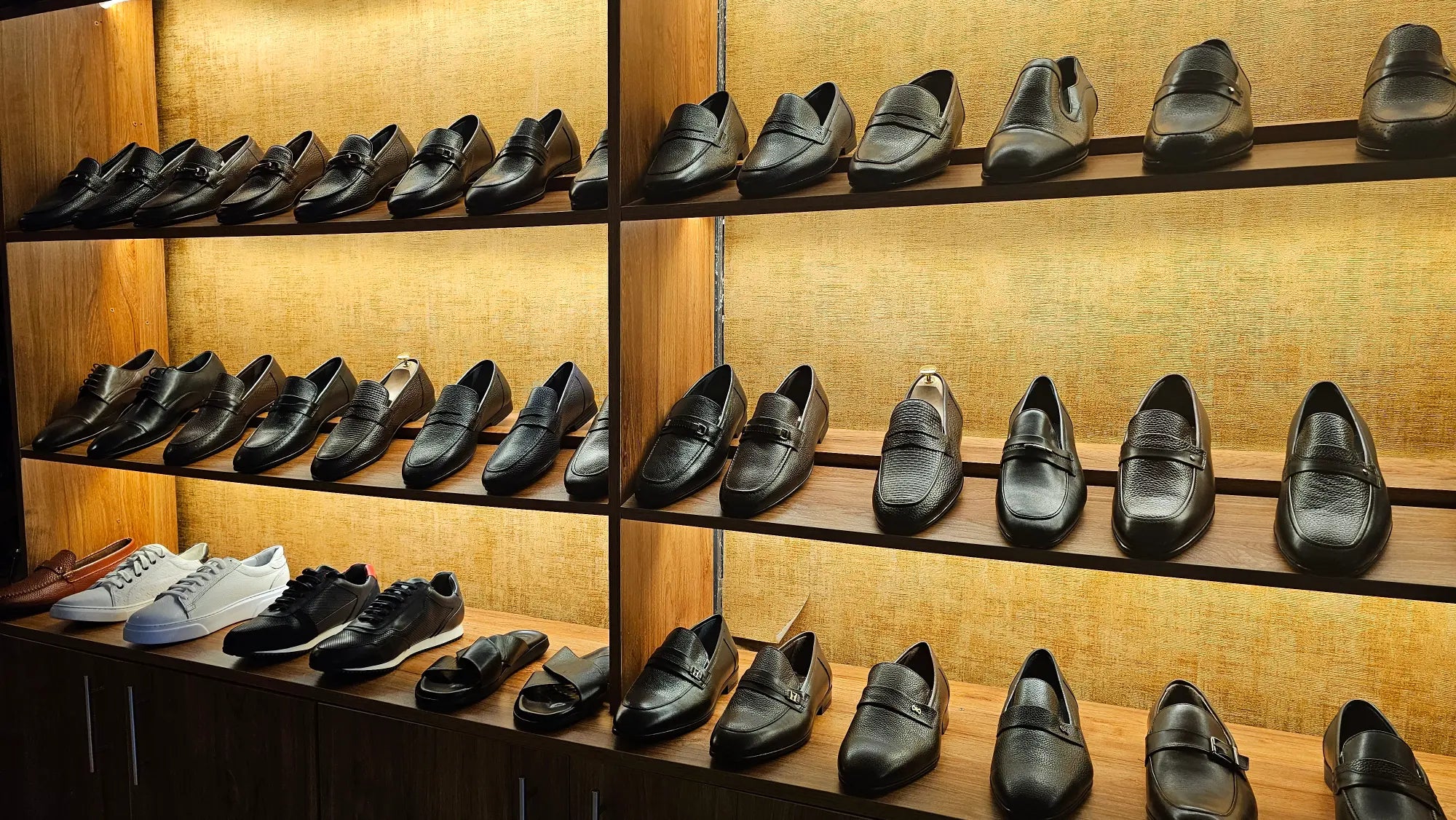 Shelves displaying a variety of men's dress shoes in a store setting.