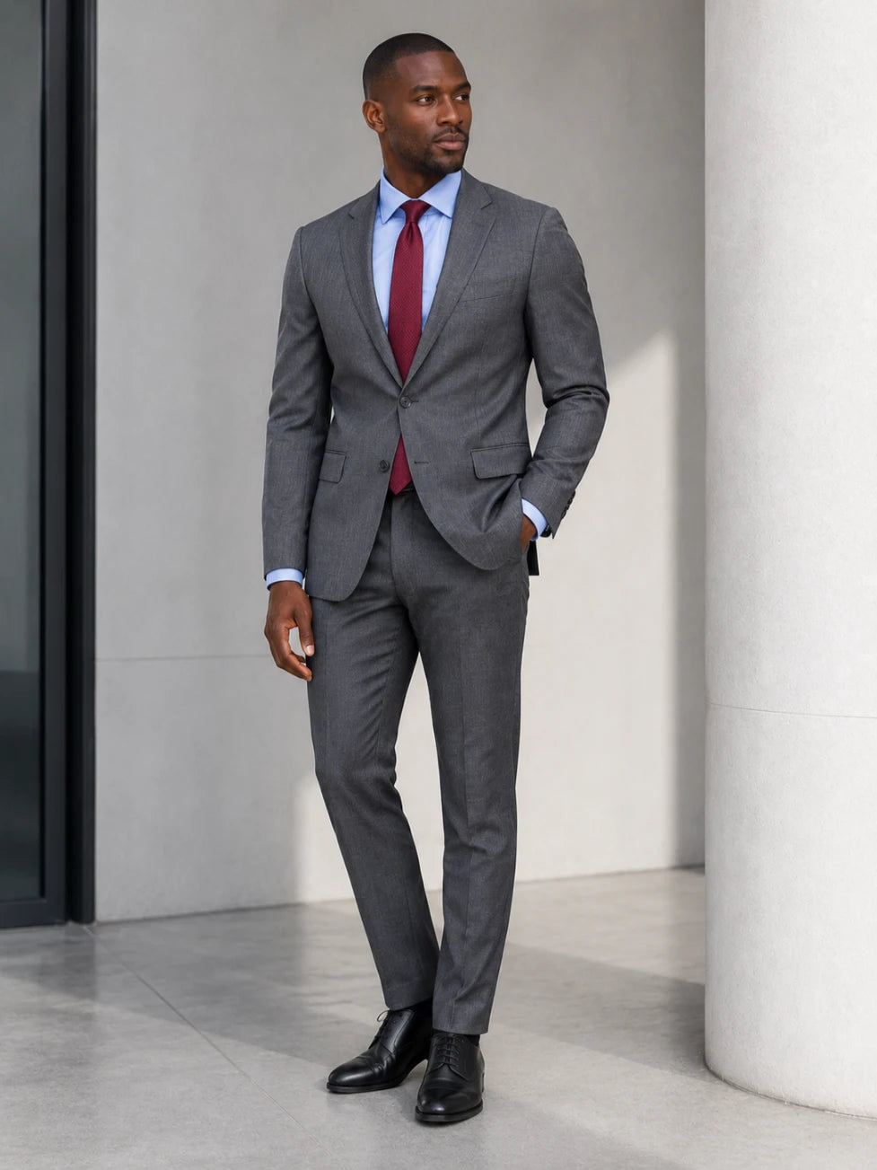 Man in a charcoal suit and burgundy tie wearing the Infynite Sky Blue Fine Stripe Slim Fit Dress Shirt with black Oxford shoes, styled for a sharp boardroom look