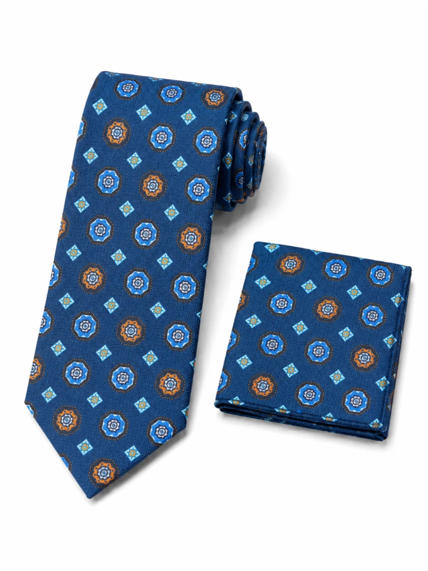 Infynite royal blue floral medallion and diamond tie and pocket square set with orange and light blue motifs laid flat on white background