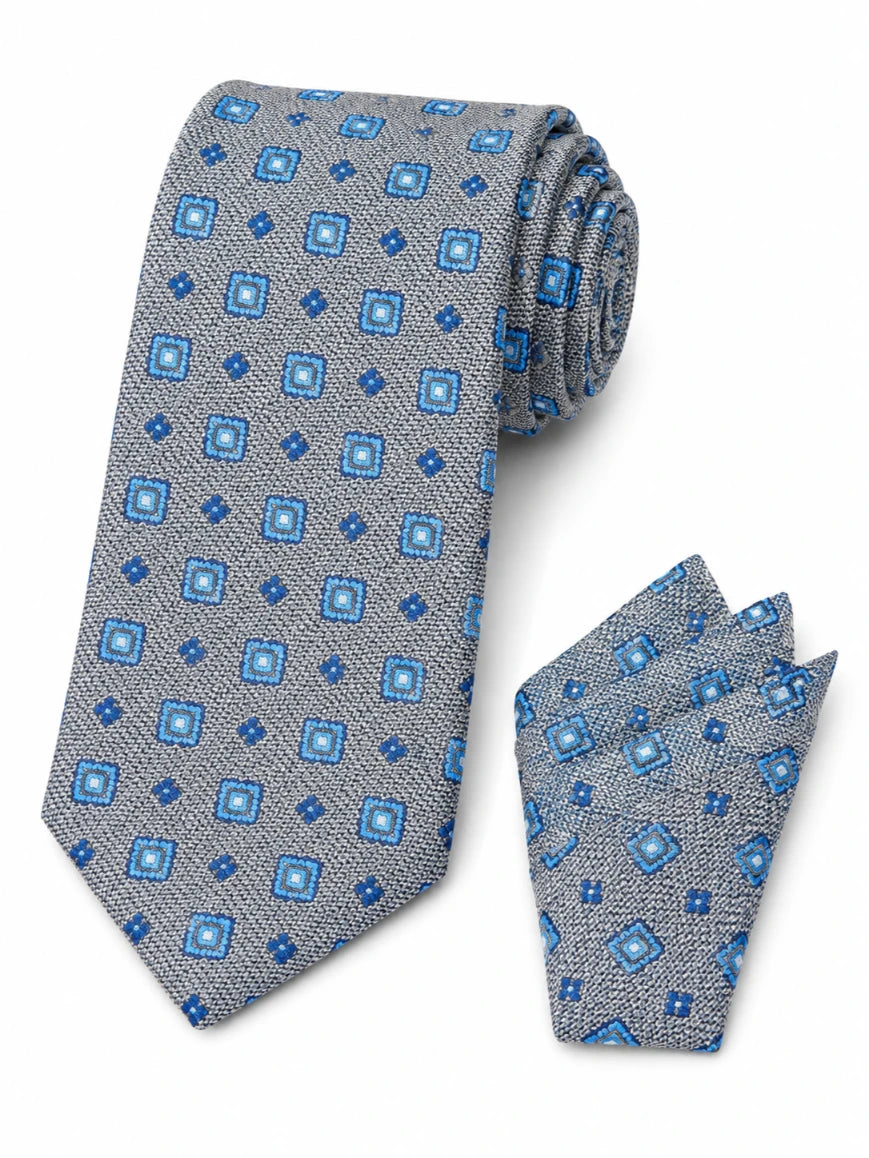Infynite silver grey and blue geometric square medallion tie and pocket square set with textured woven base laid flat on white background