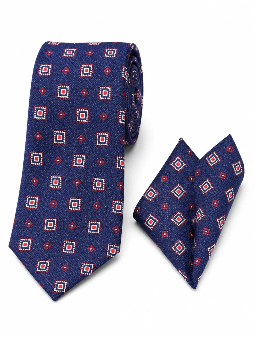 Infynite navy blue geometric square medallion and diamond tie and pocket square set with red and white dot-bordered motifs laid flat on white background