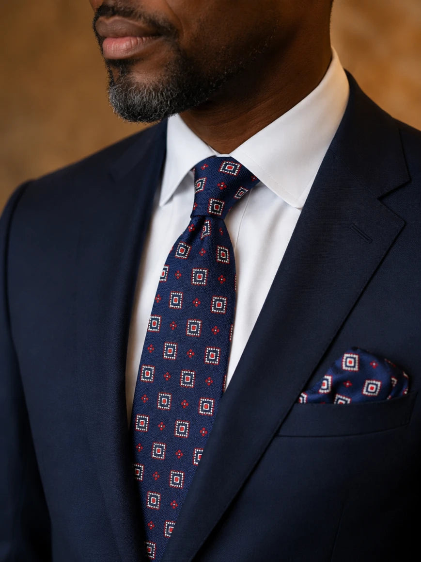Infynite navy blue geometric square medallion and diamond tie and pocket square set styled with a navy suit and white dress shirt