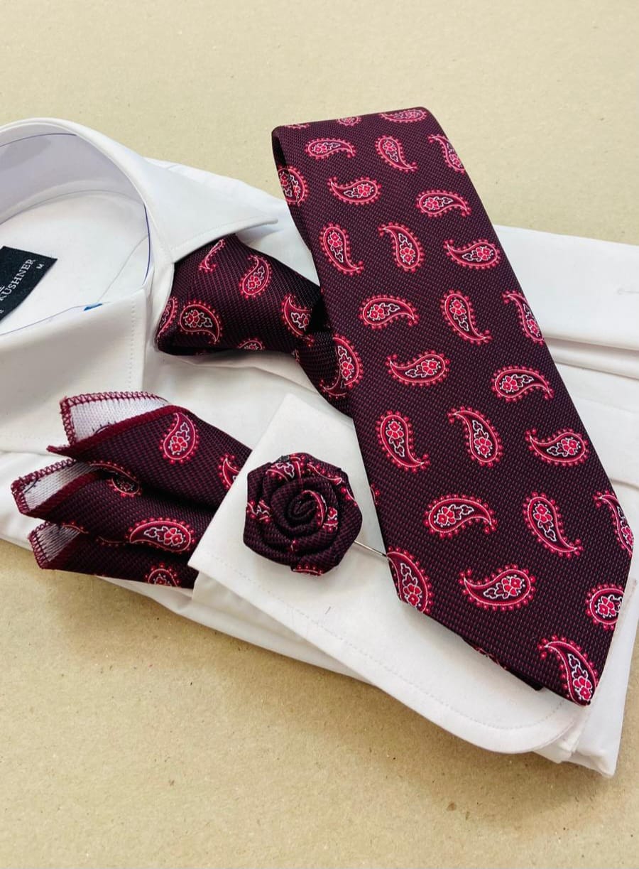Maroon paisley tie with matching pocket square and cufflinks on a white shirt.