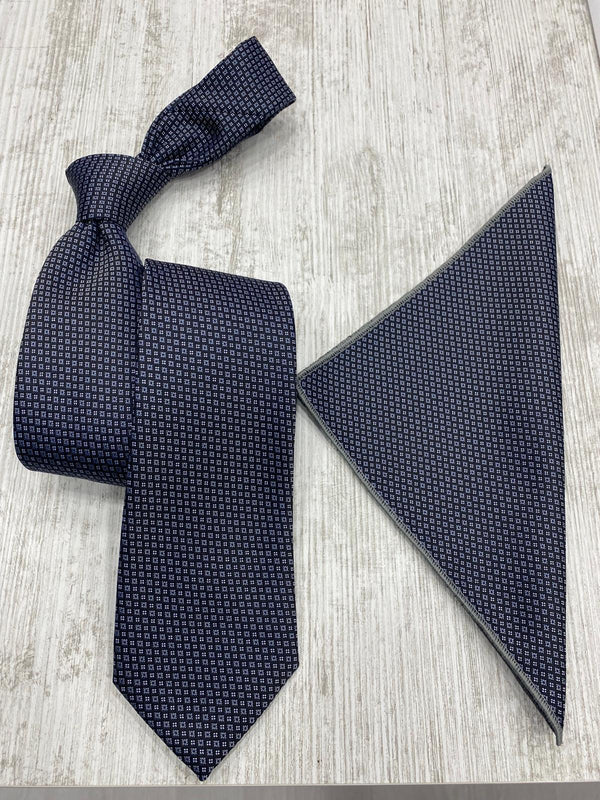 Navy patterned tie and matching pocket square on a light wooden surface