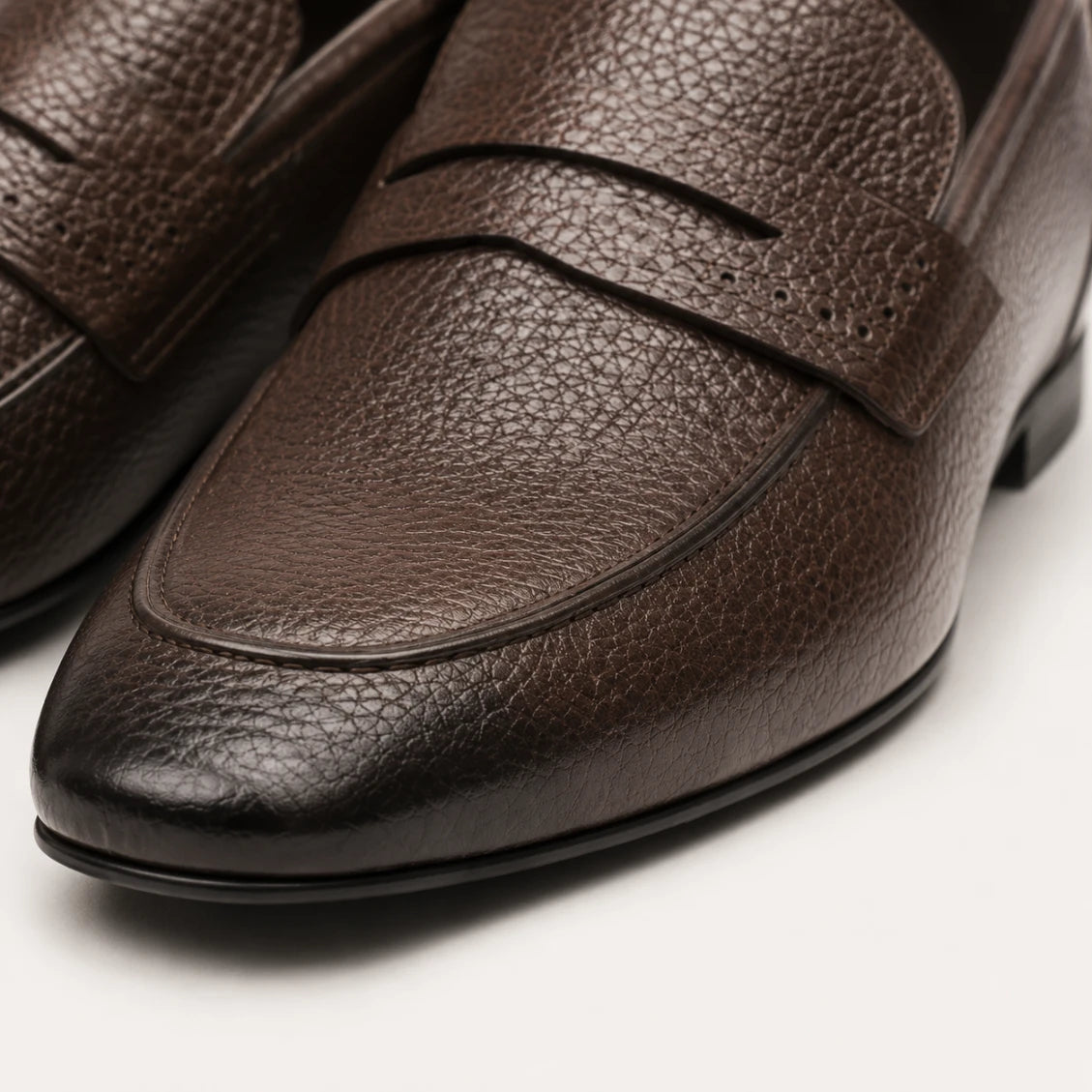 Close-up of brown leather loafers on a light background