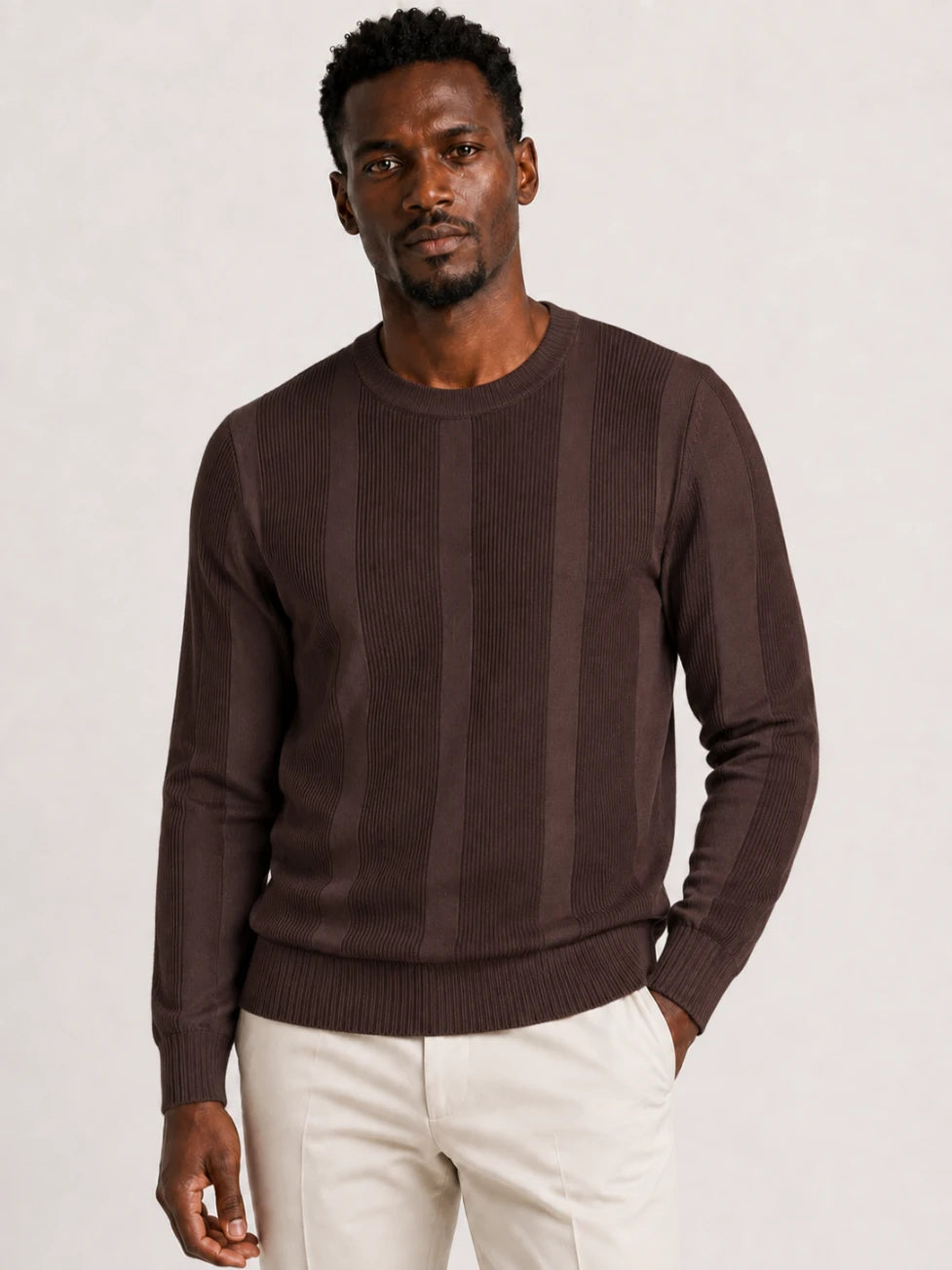 African man wearing an Infynite chocolate brown crew-neck sweater with alternating ribbed and smooth vertical knit panels.