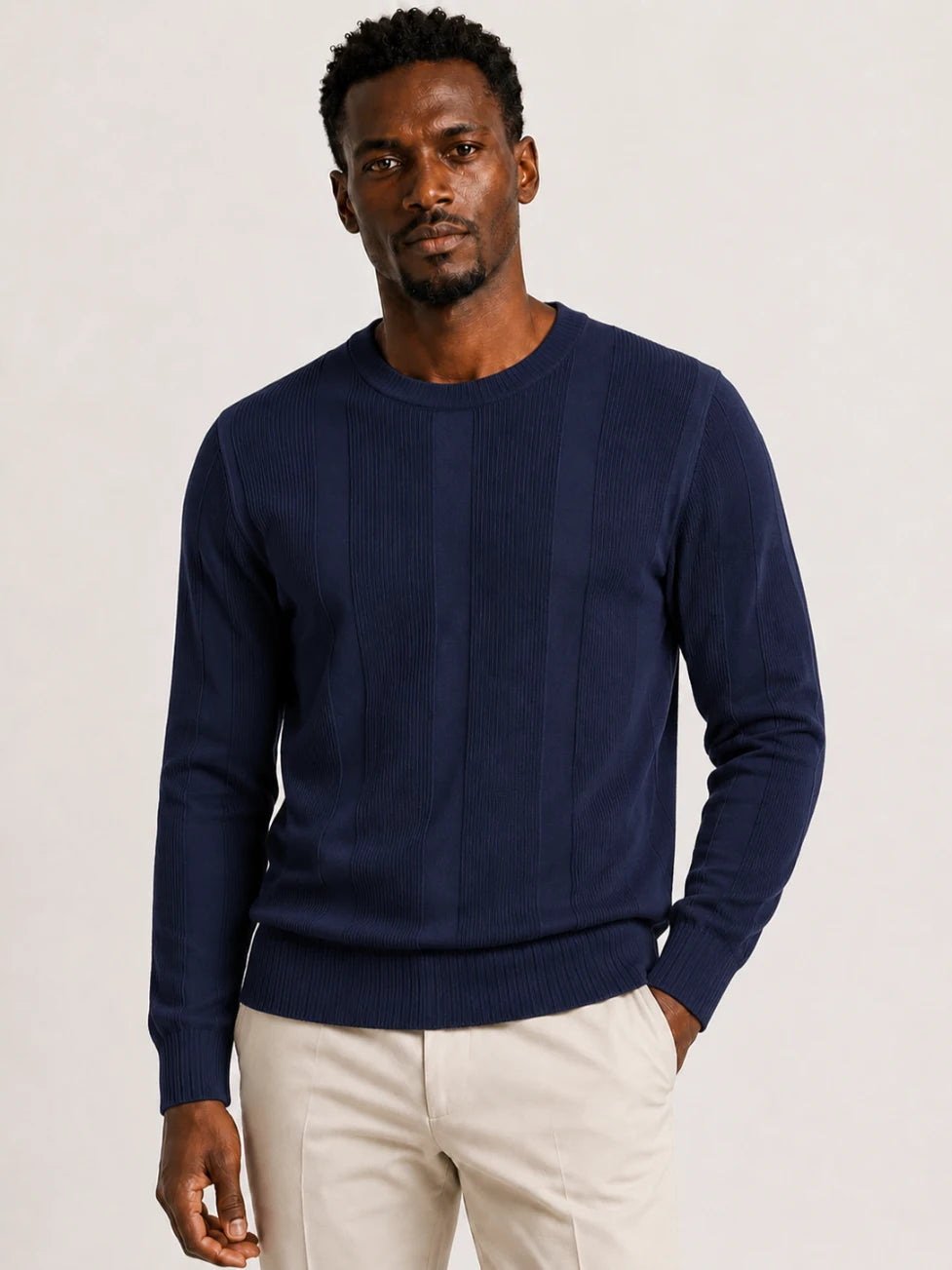 African man wearing an Infynite navy blue crew-neck sweater with alternating ribbed and smooth vertical knit panels.