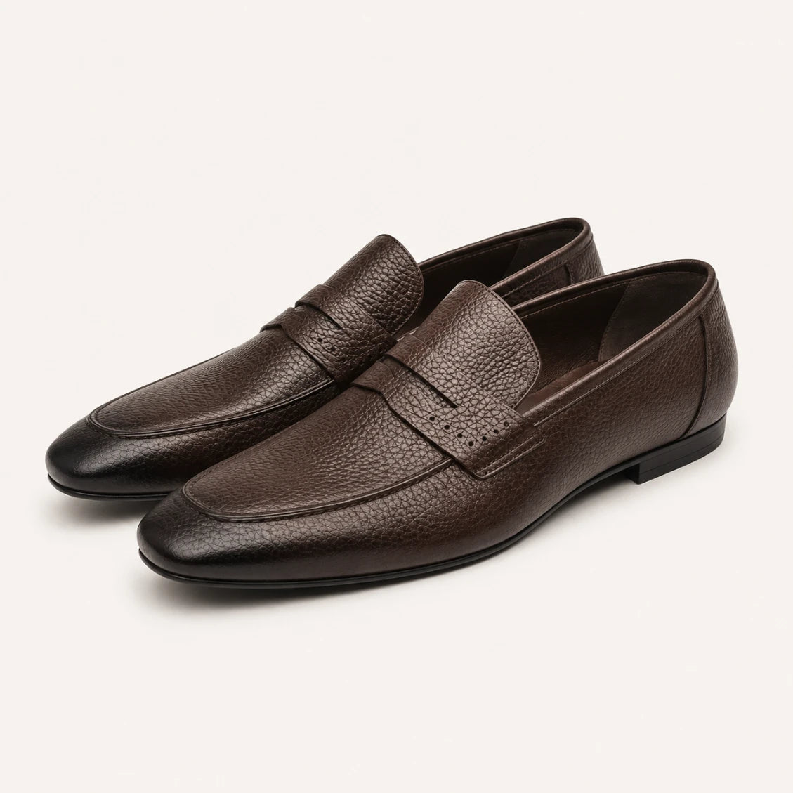 Pair of brown leather loafers on a white background