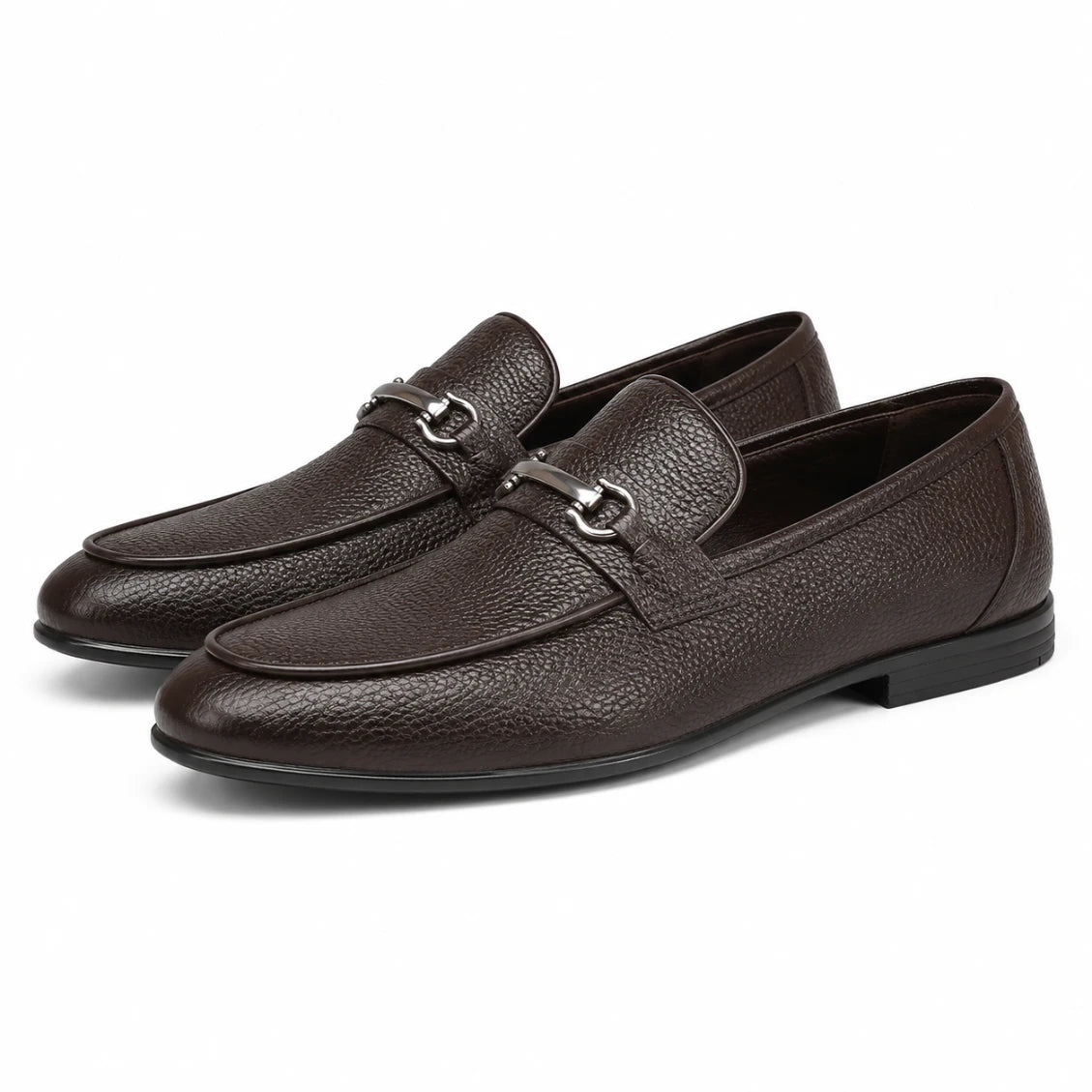 Pair of brown leather loafers with a silver buckle on a white background